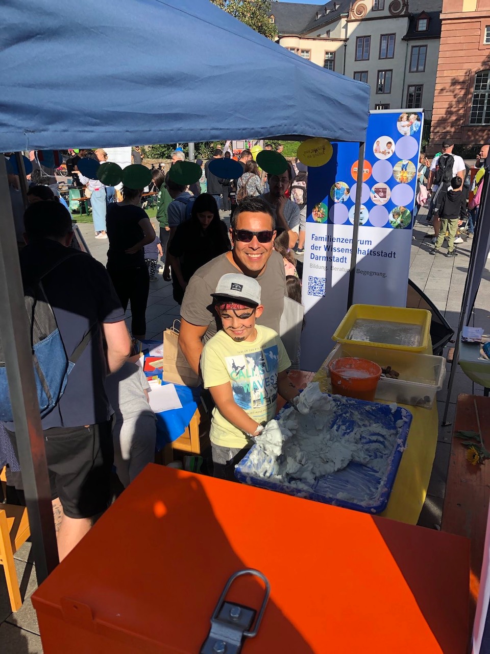 Vater und Kind mit Spielschaum am Stand des Familienzentrum Darmstadt am Weltkindertag 2023